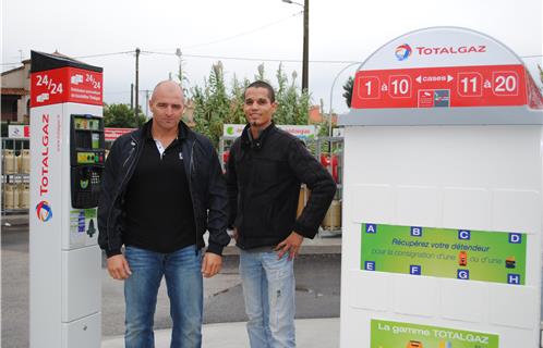 David Ornaque avec Yannick qui tient  la caisse de la pompe à essence.