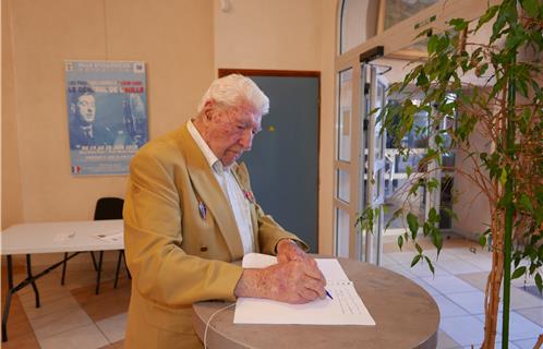 L'Amiral François Flohic, dernier aide de camp du Général de Gaulle, signe le livre d'or exposé salle Puget.