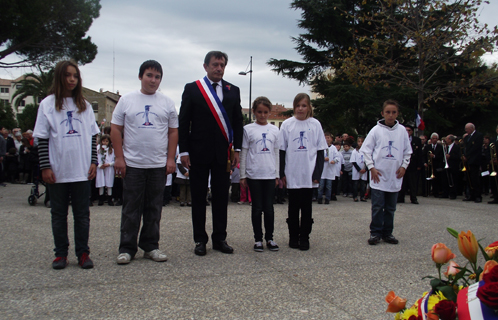 Dépôt de gerbe du député maire en compagnie d'élèves de la commune arborant un t-shirt du Souvenir Français.