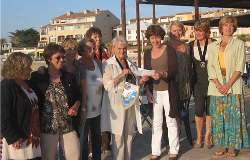 Joëlle Corneille, présidente du club services remet un chèque de 500€ aux enseignantes de l'école des Lônes.
