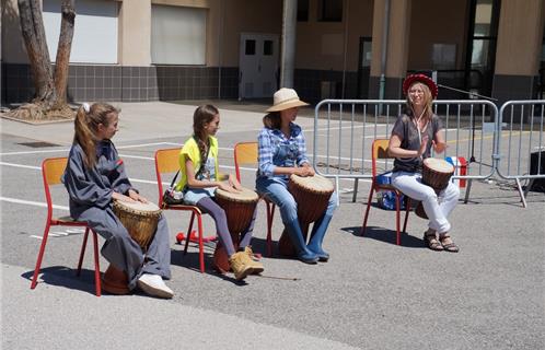 Des élèves jouant du djembé avec leur professeur de musique.