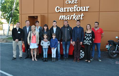 De gauche à droite : Richard Piscione directeur du Carrefour Market, Dominique et Nathalie Morin les dirigeants, devant eux Mireille la gagnante du chèque cadeau voyage, Mélanie gagnante de la C1 avec sa famille, Emmanuel Rey l'agent Citroën accompagné d'un de ses commercial, Amandine Lemaire chargée de la communication et Jérôme responsable du rayon vin.