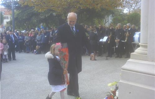 Le président du Comité de coordination Alain Trillat avec une petite fille déposant une rose.