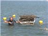 Un membre de l'APPB revient avec une barque remplie de cables