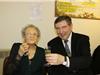 Le Maire et la centenaire partageant une coupe de champagne.