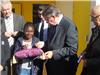 Le maire donne un bout de ruban à la conseillère municipale jeune Laure Bellemanière, 10 ans.