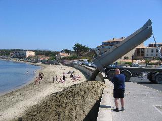 Camion entrain de déverser du sable sur la plage du Cros.