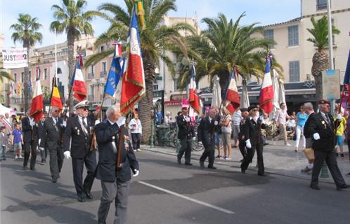 Les porte drapeaux défilent aux côtés des officiels dans le centre ville