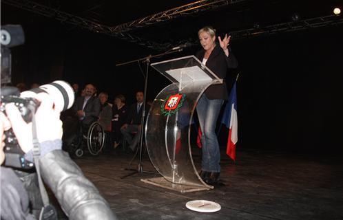 Marine Le Pen devant un pupitre avec l'emblème de la ville de Six-Fours. C'est une première...