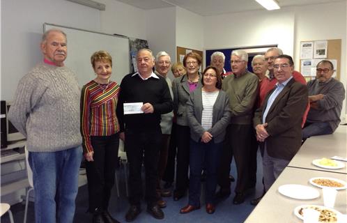 Le président de l'association VLC, Jean Lecomte, remet un chèque à Mme Dany Cayol en faveur du Téléthon, en présence des membres du bureau et des adhérents de l'association